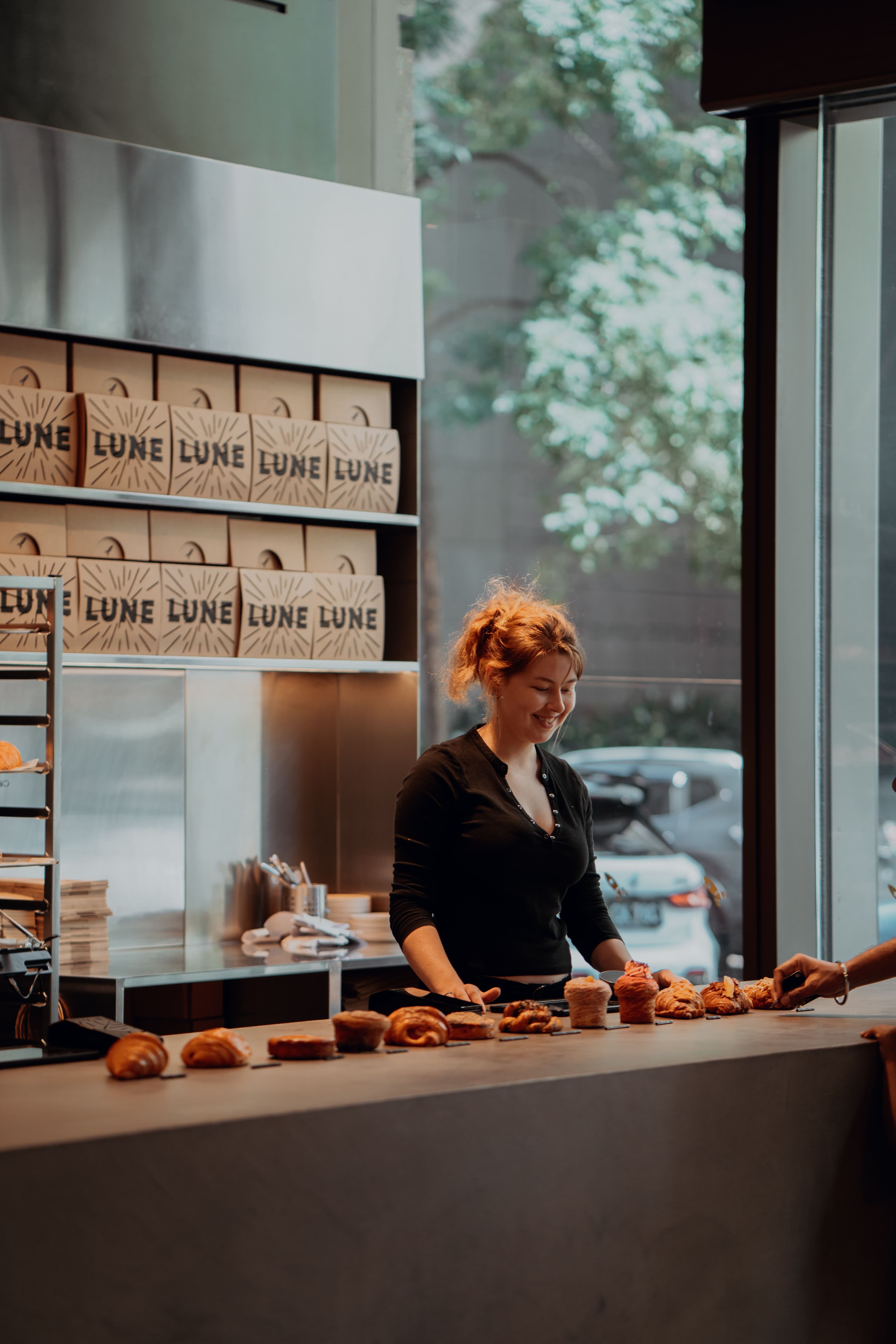 Bakery worker arranging pastries at the counter